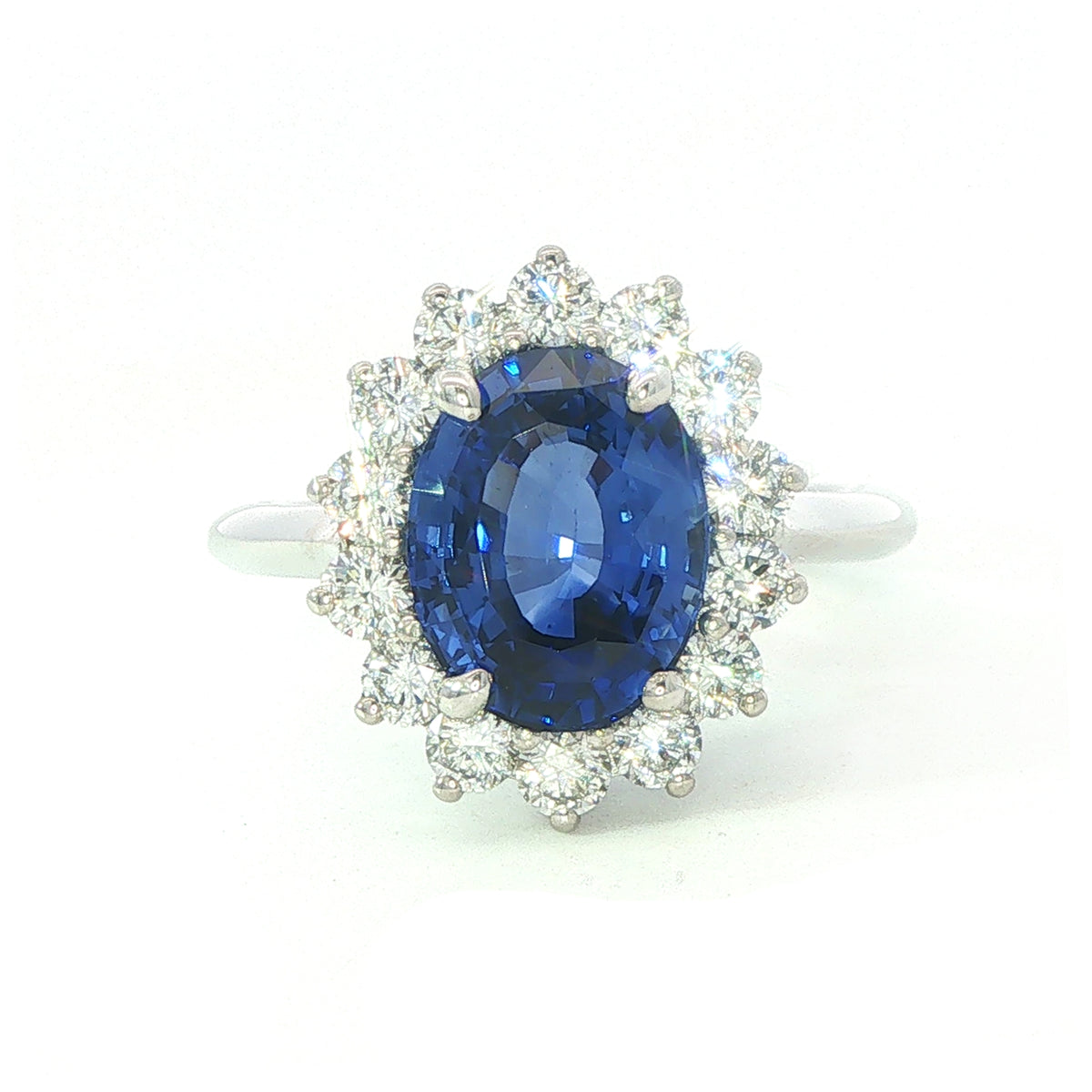 A modern 18 carat white gold Sapphire 2.64 Cts and diamond 0.42 Cts cluster ring.